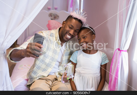 To use this stock image in your creative project, please select the size you need over to the right and click the "Add to Cart" button.
Your downloaded image will come with the Cutcaster watermark removed so don’t worry about the watermark you see on this page. Father and daughter taking selfie while sitting on bed at home stock photo, Happy father and daughter taking selfie while sitting on bed at home by Wavebreak Media