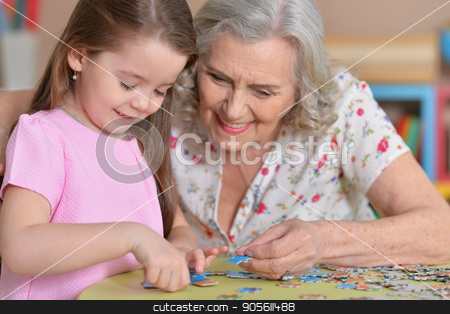 To use this stock image in your creative project, please select the size you need over to the right and click the "Add to Cart" button.
Your downloaded image will come with the Cutcaster watermark removed so don’t worry about the watermark you see on this page. Grandmother collecting puzzle stock photo, Portrait of a grandmother collecting puzzle with her granddaughter by Ruslan Huzau