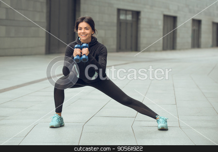 To use this stock image in your creative project, please select the size you need over to the right and click the "Add to Cart" button.
Your downloaded image will come with the Cutcaster watermark removed so don’t worry about the watermark you see on this page. Young woman active exercise workout on street outdoor stock photo, Young femaleactive exercise workout on street outside with dumbbells by Dmytro Sidelnikov