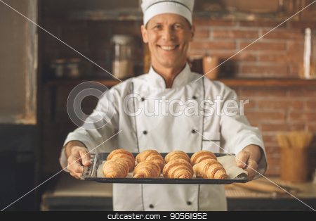 To use this stock image in your creative project, please select the size you need over to the right and click the "Add to Cart" button.
Your downloaded image will come with the Cutcaster watermark removed so don’t worry about the watermark you see on this page. Bakery chef cooking bake in the kitchen professional stock photo, Bakery chef cooking bake in the kitchen professional holding croissants by Dmytro Sidelnikov