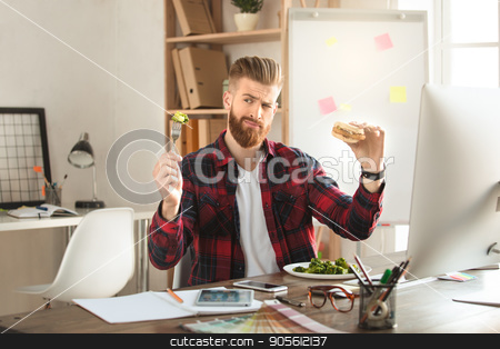 To use this stock image in your creative project, please select the size you need over to the right and click the "Add to Cart" button.
Your downloaded image will come with the Cutcaster watermark removed so don’t worry about the watermark you see on this page. Young man architect working in the office ocuupation stock photo, Young male architect working indoors eating lunch by Dmytro Sidelnikov