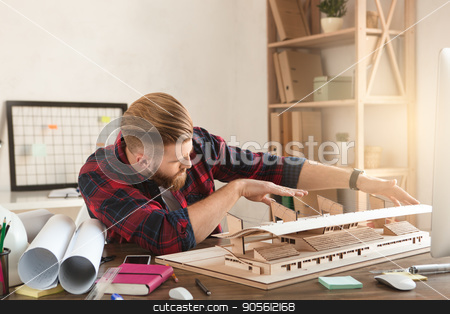 To use this stock image in your creative project, please select the size you need over to the right and click the "Add to Cart" button.
Your downloaded image will come with the Cutcaster watermark removed so don’t worry about the watermark you see on this page. Young man architect working in the office ocuupation stock photo, Young male architect working indoors model construction by Dmytro Sidelnikov