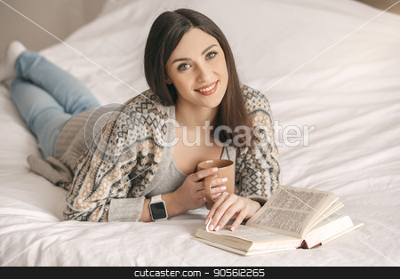 To use this stock image in your creative project, please select the size you need over to the right and click the "Add to Cart" button.
Your downloaded image will come with the Cutcaster watermark removed so don’t worry about the watermark you see on this page. Young woman lie on bed with a book rest stock photo, Young girl lie on bed reading a book drinking tea by Dmytro Sidelnikov