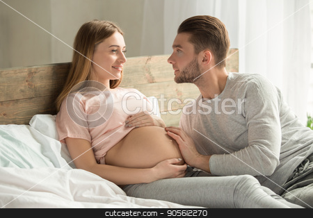 To use this stock image in your creative project, please select the size you need over to the right and click the "Add to Cart" button.
Your downloaded image will come with the Cutcaster watermark removed so don’t worry about the watermark you see on this page. Young couple expecting baby relax on bed indoors stock photo, Young couple man and woman expecting baby relax on bed at home by Dmytro Sidelnikov