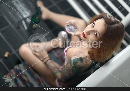 To use this stock image in your creative project, please select the size you need over to the right and click the "Add to Cart" button.
Your downloaded image will come with the Cutcaster watermark removed so don’t worry about the watermark you see on this page. Beautiful girl with colorful tattoos sits near white bath on the stock photo, Beautiful girl with colorful tattoos sits near white bath on the motley carpet on the dark tiled floor in the bathroom. She holds a glass and looks into the camera. Top view photo. Indoors by bezikus