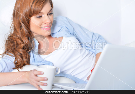 To use this stock image in your creative project, please select the size you need over to the right and click the "Add to Cart" button.
Your downloaded image will come with the Cutcaster watermark removed so don’t worry about the watermark you see on this page. Young woman lying with laptop stock photo, Beautiful young woman lying on couch with laptop and cup of tea by Ruslan Huzau