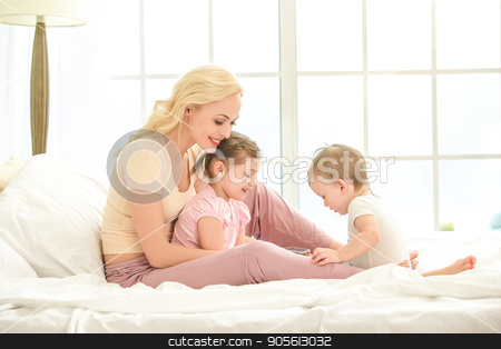 To use this stock image in your creative project, please select the size you need over to the right and click the "Add to Cart" button.
Your downloaded image will come with the Cutcaster watermark removed so don’t worry about the watermark you see on this page. Young mother and daughters morning on bed indoors stock photo, Young mother and daughters morning on bed at home using digital device by Dmytro Sidelnikov