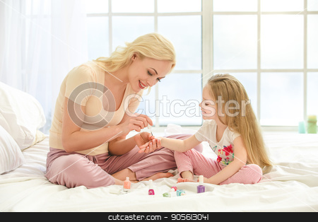 To use this stock image in your creative project, please select the size you need over to the right and click the "Add to Cart" button.
Your downloaded image will come with the Cutcaster watermark removed so don’t worry about the watermark you see on this page. Young mother and daughter morning on bed indoors stock photo, Young mother and daughter morning on bed at home color nails by Dmytro Sidelnikov