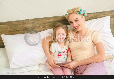 To use this stock image in your creative project, please select the size you need over to the right and click the "Add to Cart" button.
Your downloaded image will come with the Cutcaster watermark removed so don’t worry about the watermark you see on this page. Young mother and daughter morning on bed indoors stock photo, Young mother and daughter morning on bed at home using digital device by Dmytro Sidelnikov