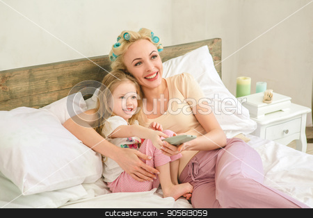 To use this stock image in your creative project, please select the size you need over to the right and click the "Add to Cart" button.
Your downloaded image will come with the Cutcaster watermark removed so don’t worry about the watermark you see on this page. Young mother and daughter morning on bed indoors stock photo, Young mother and daughter morning on bed at home watching tv by Dmytro Sidelnikov