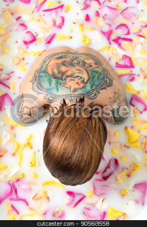 To use this stock image in your creative project, please select the size you need over to the right and click the "Add to Cart" button.
Your downloaded image will come with the Cutcaster watermark removed so don’t worry about the watermark you see on this page. Tattooed girl relaxing in bath stock photo, Gorgeous girl with wet hair sits in the bath full of water with milk and flower petals. She has a colorful fox tattoo on the back and another tattoos on her shoulders. Top view photo. Indoors by bezikus
