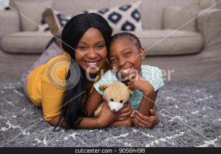 To use this stock image in your creative project, please select the size you need over to the right and click the "Add to Cart" button.
Your downloaded image will come with the Cutcaster watermark removed so don’t worry about the watermark you see on this page. Mother and daughter holding teddy bear while lying on rug at home stock photo, Portrait of mother and daughter holding teddy bear while lying on rug at home by Wavebreak Media