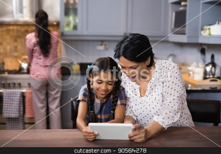 To use this stock image in your creative project, please select the size you need over to the right and click the "Add to Cart" button.
Your downloaded image will come with the Cutcaster watermark removed so don’t worry about the watermark you see on this page. Grandmother and granddaughter using digital tablet in kitchen stock photo, Grandmother and granddaughter using digital tablet together in kitchen at home by Wavebreak Media