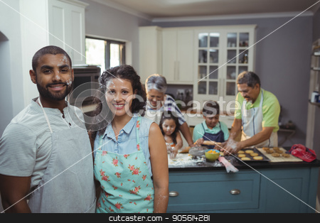 To use this stock image in your creative project, please select the size you need over to the right and click the "Add to Cart" button.
Your downloaded image will come with the Cutcaster watermark removed so don’t worry about the watermark you see on this page. Couple smiling at camera while family members preparing dessert in background stock photo, Couple smiling at camera while family members preparing dessert in background at home by Wavebreak Media