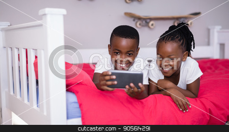 To use this stock image in your creative project, please select the size you need over to the right and click the "Add to Cart" button.
Your downloaded image will come with the Cutcaster watermark removed so don’t worry about the watermark you see on this page. Siblings using mobile phone while lying on bed at home stock photo, Happy siblings using mobile phone while lying on bed at home by Wavebreak Media
