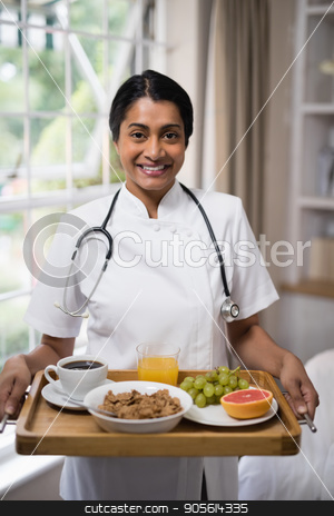 To use this stock image in your creative project, please select the size you need over to the right and click the "Add to Cart" button.
Your downloaded image will come with the Cutcaster watermark removed so don’t worry about the watermark you see on this page. Smiling nurse holding breakfast tray at home stock photo, Portrait of smiling nurse holding breakfast tray at home by Wavebreak Media
