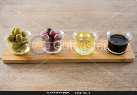 To use this stock image in your creative project, please select the size you need over to the right and click the "Add to Cart" button.
Your downloaded image will come with the Cutcaster watermark removed so don’t worry about the watermark you see on this page. Marinated olives with olive oil and balsamic vinegar in glass container on a wooden tray stock photo, Close-up of marinated olives with olive oil and balsamic vinegar in glass container on a wooden tray by Wavebreak Media