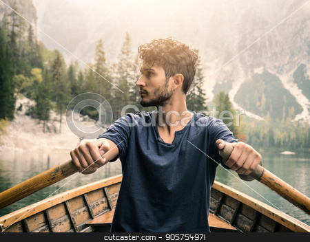 To use this stock image in your creative project, please select the size you need over to the right and click the "Add to Cart" button.
Your downloaded image will come with the Cutcaster watermark removed so don’t worry about the watermark you see on this page. Handsome man rowing in boat stock photo, Young casual man sitting in boat and rowing while looking away on background of lake and mountains. by Stefano Cavoretto