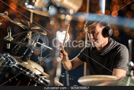 To use this stock image in your creative project, please select the size you need over to the right and click the "Add to Cart" button.
Your downloaded image will come with the Cutcaster watermark removed so don’t worry about the watermark you see on this page. male musician playing drum kit at concert stock photo, music, people, musical instruments and entertainment concept - male musician in headphones with drumsticks playing drum kit at concert or studio over holidays lights background by Syda Productions