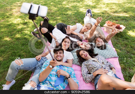 To use this stock image in your creative project, please select the size you need over to the right and click the "Add to Cart" button.
Your downloaded image will come with the Cutcaster watermark removed so don’t worry about the watermark you see on this page. friends taking picture by selfie stick at picnic stock photo, friendship, leisure and technology concept - group of happy smiling friends taking picture by selfie stick chilling on picnic blanket at summer park by Syda Productions