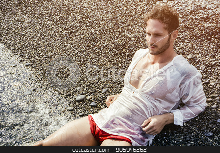 To use this stock image in your creative project, please select the size you need over to the right and click the "Add to Cart" button.
Your downloaded image will come with the Cutcaster watermark removed so don’t worry about the watermark you see on this page. Handsome muscular man on the beach laying on gravel stock photo, Handsome muscular man on the beach lying on gravel, wearing wet white shirt by Stefano Cavoretto