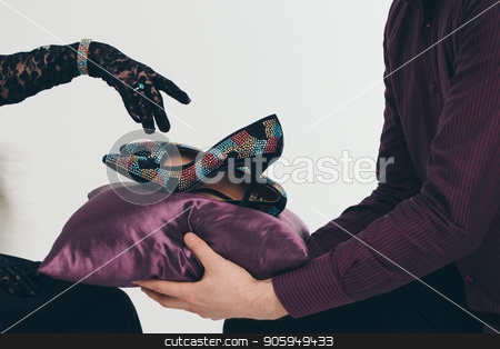 To use this stock image in your creative project, please select the size you need over to the right and click the "Add to Cart" button.
Your downloaded image will come with the Cutcaster watermark removed so don’t worry about the watermark you see on this page. The shoes in jewels on a purple pillow. A man brings shoes to a girl, she points her finger at them in a black glove. stock photo, The shoes in jewels on a purple pillow. A man brings shoes to a girl, she points her finger at them in a black glove. by aaalll3110