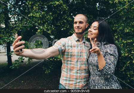 To use this stock image in your creative project, please select the size you need over to the right and click the "Add to Cart" button.
Your downloaded image will come with the Cutcaster watermark removed so don’t worry about the watermark you see on this page. A guy with a girl taking selfies on a green foliage background stock photo, A guy with a girl taking selfies on a green foliage background by aaalll3110