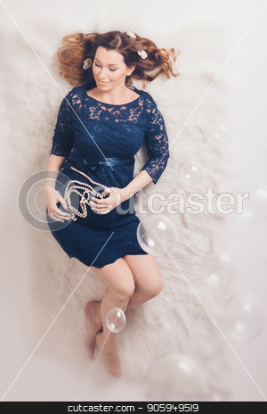 To use this stock image in your creative project, please select the size you need over to the right and click the "Add to Cart" button.
Your downloaded image will come with the Cutcaster watermark removed so don’t worry about the watermark you see on this page. a pregnant woman in a blue dress lying on the floor and holding a of pearls on a background of stomach stock photo, a pregnant woman in a blue dress lying on the floor and holding a of pearls on a background of stomach by aaalll3110