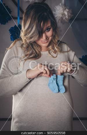 To use this stock image in your creative project, please select the size you need over to the right and click the "Add to Cart" button.
Your downloaded image will come with the Cutcaster watermark removed so don’t worry about the watermark you see on this page. pregnant woman holding baby booties on the belly. fashion for newborns. Children's shoes advertising stock photo, pregnant woman holding baby booties on the belly. fashion for newborns. Children's shoes advertising by aaalll3110