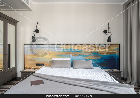 To use this stock image in your creative project, please select the size you need over to the right and click the "Add to Cart" button.
Your downloaded image will come with the Cutcaster watermark removed so don’t worry about the watermark you see on this page. Stylish hotel room stock photo, Comfortable hotel room with light walls and a striped floor. There is a double bed with a colorful wooden bedhead, dark gray nightstands and a wardrobe with mirrors, black lamps on the wall. by bezikus