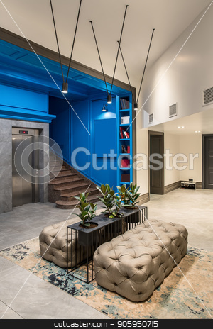 To use this stock image in your creative project, please select the size you need over to the right and click the "Add to Cart" button.
Your downloaded image will come with the Cutcaster watermark removed so don’t worry about the watermark you see on this page. Stylish interior in hotel stock photo, Modern hallway in the hotel with blue and light walls and a tiled floor. There is a lift, brown stair, shelves with books, black stand with green plants in the pots, sofas, luminous lamps, doors. by bezikus