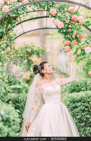 To use this stock image in your creative project, please select the size you need over to the right and click the "Add to Cart" button.
Your downloaded image will come with the Cutcaster watermark removed so don’t worry about the watermark you see on this page. Half-length side portrait of the bride touching the roses on the arch. stock photo, Half-length side portrait of the bride touching the roses on the arch by Andrii Kobryn