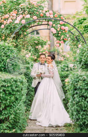 To use this stock image in your creative project, please select the size you need over to the right and click the "Add to Cart" button.
Your downloaded image will come with the Cutcaster watermark removed so don’t worry about the watermark you see on this page. Full-length photo of the hugging newlyweds under the roses arch. stock photo, Full-length photo of the hugging newlyweds under the roses arch by Andrii Kobryn