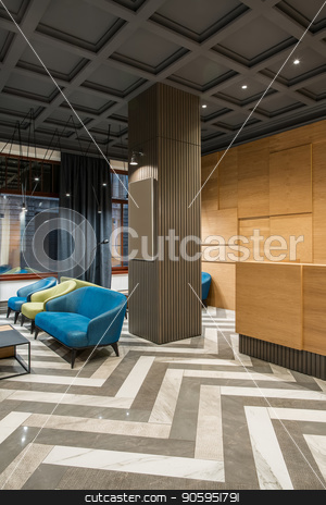 To use this stock image in your creative project, please select the size you need over to the right and click the "Add to Cart" button.
Your downloaded image will come with the Cutcaster watermark removed so don’t worry about the watermark you see on this page. Stylish interior in hotel stock photo, Fine interior with luminous lamps in the hotel with dark ceiling and patterned tiled floor. There is a wooden reception, column, multicolored armchairs and sofas, tables, windows with curtains. by bezikus