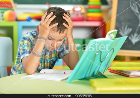 To use this stock image in your creative project, please select the size you need over to the right and click the "Add to Cart" button.
Your downloaded image will come with the Cutcaster watermark removed so don’t worry about the watermark you see on this page. schoolboy doing homework stock photo, Portrait of tired schoolboy doing homework in classroom by Ruslan Huzau