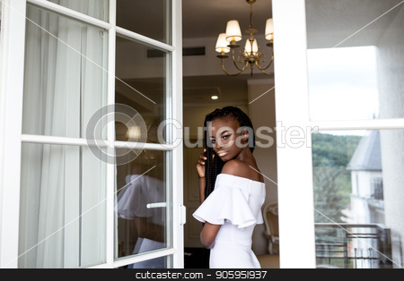 To use this stock image in your creative project, please select the size you need over to the right and click the "Add to Cart" button.
Your downloaded image will come with the Cutcaster watermark removed so don’t worry about the watermark you see on this page. African american girl posing by open window or door wearing white dress. stock photo, African american girl posing by open window or door wearing white dress. by Andrii Kobryn
