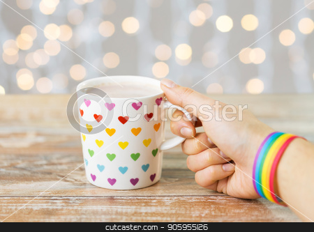 To use this stock image in your creative project, please select the size you need over to the right and click the "Add to Cart" button.
Your downloaded image will come with the Cutcaster watermark removed so don’t worry about the watermark you see on this page. hand with cup of cacao and gay awareness wristband stock photo, homosexual and lgbt concept - female hand with cacao drink in cup with rainbow colored heart pattern and gay pride awareness wristband with festive lights background by Syda Productions