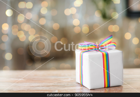 To use this stock image in your creative project, please select the size you need over to the right and click the "Add to Cart" button.
Your downloaded image will come with the Cutcaster watermark removed so don’t worry about the watermark you see on this page. present with gay awareness ribbon on table stock photo, homosexual and lgbt concept - gift box with gay pride awareness ribbon on wooden table over festive lights background by Syda Productions