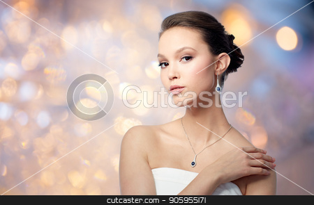 To use this stock image in your creative project, please select the size you need over to the right and click the "Add to Cart" button.
Your downloaded image will come with the Cutcaster watermark removed so don’t worry about the watermark you see on this page. beautiful asian woman with earring and pendant stock photo, beauty, jewelry, people and luxury concept - beautiful asian woman or bride with earring and pendant over holidays lights background by Syda Productions