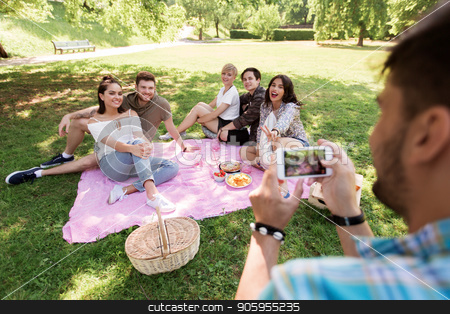 To use this stock image in your creative project, please select the size you need over to the right and click the "Add to Cart" button.
Your downloaded image will come with the Cutcaster watermark removed so don’t worry about the watermark you see on this page. man photographing friends by smartphone at picnic stock photo, friendship, leisure and technology concept - man taking picture of his friends by smartphone on picnic at summer park by Syda Productions