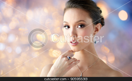 To use this stock image in your creative project, please select the size you need over to the right and click the "Add to Cart" button.
Your downloaded image will come with the Cutcaster watermark removed so don’t worry about the watermark you see on this page. beautiful woman with earring, ring and pendant stock photo, beauty, jewelry, people and luxury concept - beautiful asian woman or bride with earring, finger ring and pendant over holidays lights background by Syda Productions