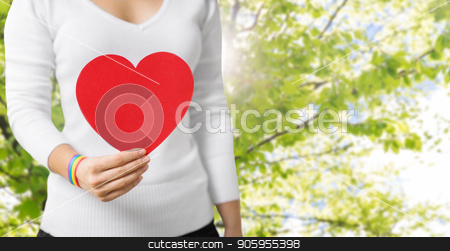 To use this stock image in your creative project, please select the size you need over to the right and click the "Add to Cart" button.
Your downloaded image will come with the Cutcaster watermark removed so don’t worry about the watermark you see on this page. woman with gay awareness wristband holding heart stock photo, homosexual and lgbt concept - woman holding red heart shape and wearing gay pride awareness ribbon wristband over natural summer background by Syda Productions