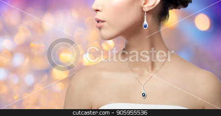 To use this stock image in your creative project, please select the size you need over to the right and click the "Add to Cart" button.
Your downloaded image will come with the Cutcaster watermark removed so don’t worry about the watermark you see on this page. close up of woman with earring and pendant stock photo, beauty, jewelry, people and luxury concept - close up of beautiful asian woman or bride with earring and pendant over holidays lights background by Syda Productions
