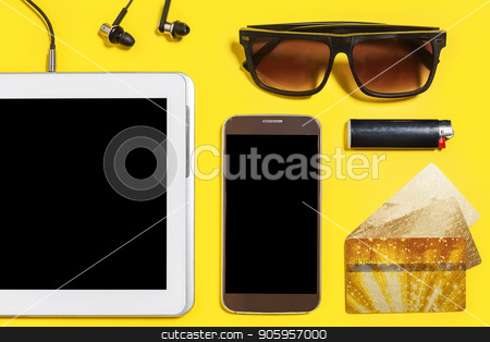 To use this stock image in your creative project, please select the size you need over to the right and click the "Add to Cart" button.
Your downloaded image will come with the Cutcaster watermark removed so don’t worry about the watermark you see on this page. collection of modern people attributes on a yellow background stock photo, tablet pc, smartphone earphones, cigarette lighter, sock, sunglasses and a gold bank cards lying on a yellow surface. concept of modern people accessories. top view by Oleh