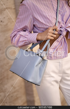 To use this stock image in your creative project, please select the size you need over to the right and click the "Add to Cart" button.
Your downloaded image will come with the Cutcaster watermark removed so don’t worry about the watermark you see on this page. Model with bag outdoors stock photo, Cute girl is posing with a light blue bag on the wall background outdoors. She wears a white pants and a colorful striped shirt. Closeup vertical photo. by bezikus