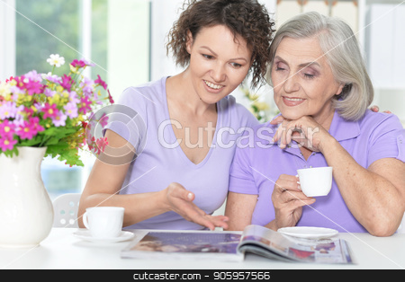 To use this stock image in your creative project, please select the size you need over to the right and click the "Add to Cart" button.
Your downloaded image will come with the Cutcaster watermark removed so don’t worry about the watermark you see on this page. Senior woman with daughter stock photo, Portrait of Senior woman with daughter reading magazine at home by Ruslan Huzau