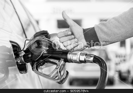 To use this stock image in your creative project, please select the size you need over to the right and click the "Add to Cart" button.
Your downloaded image will come with the Cutcaster watermark removed so don’t worry about the watermark you see on this page. Petrol or gasoline being pumped into a motor vehicle car. Closeup of man, showing thumb up gesture, pumping gasoline fuel in car at gas station. stock photo, Petrol or gasoline being pumped into a motor vehicle car. Closeup of mans hand showing thumb up gesture, pumping gasoline fuel in car at gas station. Black and white image. by kasto