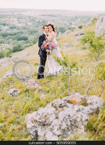 To use this stock image in your creative project, please select the size you need over to the right and click the "Add to Cart" button.
Your downloaded image will come with the Cutcaster watermark removed so don’t worry about the watermark you see on this page. Romantic view of the hugging newlyweds standing on the rocks. stock photo, Romantic view of the hugging newlyweds standing on the rocks by Andrii Kobryn