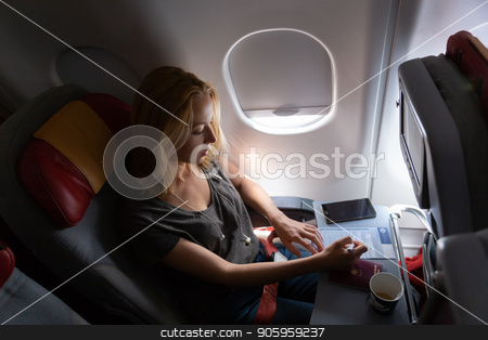 To use this stock image in your creative project, please select the size you need over to the right and click the "Add to Cart" button.
Your downloaded image will come with the Cutcaster watermark removed so don’t worry about the watermark you see on this page. Casual woman flying on commercial passengers airplane, filling in immigration form. stock photo, Relaxed casual woman flying on commercial passengers airplane, filling in immigration form, drinking coffee, listening to music. by kasto