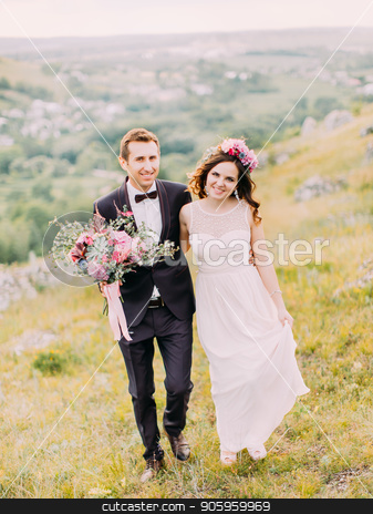 To use this stock image in your creative project, please select the size you need over to the right and click the "Add to Cart" button.
Your downloaded image will come with the Cutcaster watermark removed so don’t worry about the watermark you see on this page. Happy newlywed couple is holding hands while walking in the mountains. stock photo, Happy newlywed couple is holding hands while walking in the mountains by Andrii Kobryn